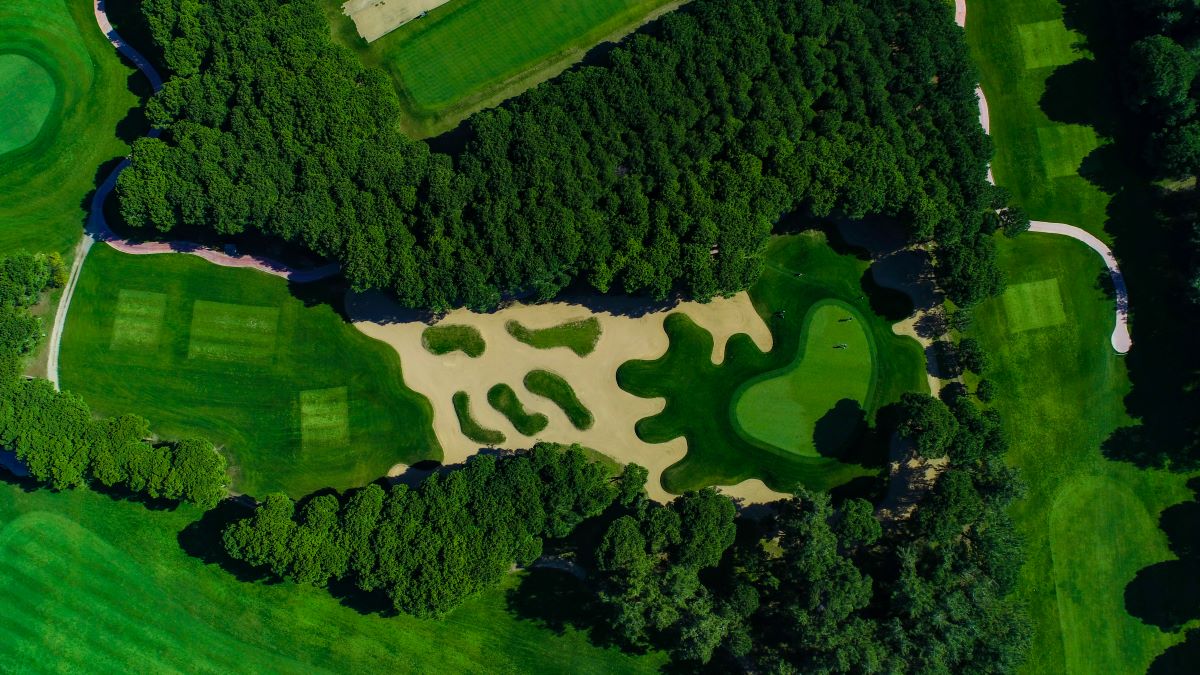 Sand traps and trees protecting the putting green at Montgomerie Maxx Royal Golf Course