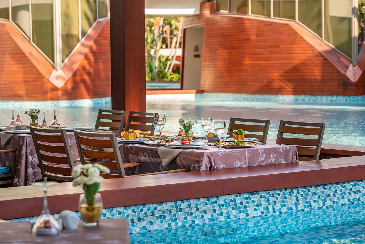 Outdoor dining by the swimming pool at Cornelia Diamond Resort