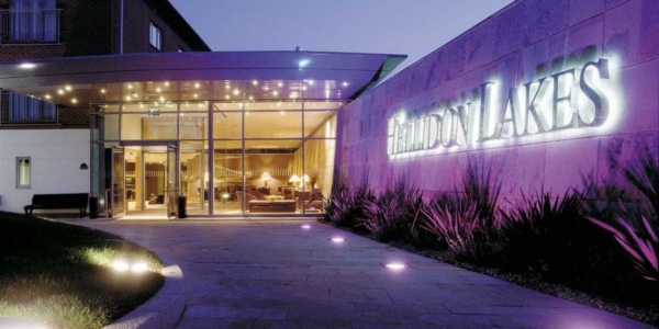 Main entrance to Hellidon Lakes Golf & Spa Hotel at night with illuminated sign