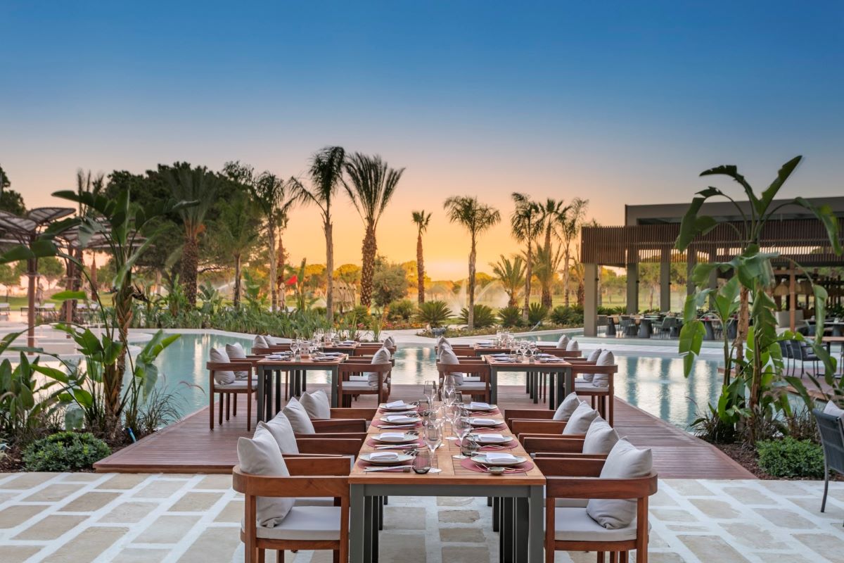 Outdoor dining at Cullian Belek Resort with palm trees in the distance