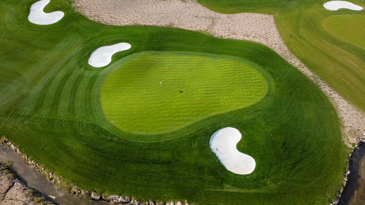 Lush green fairway surrounding putting green at Titanic Golf Club