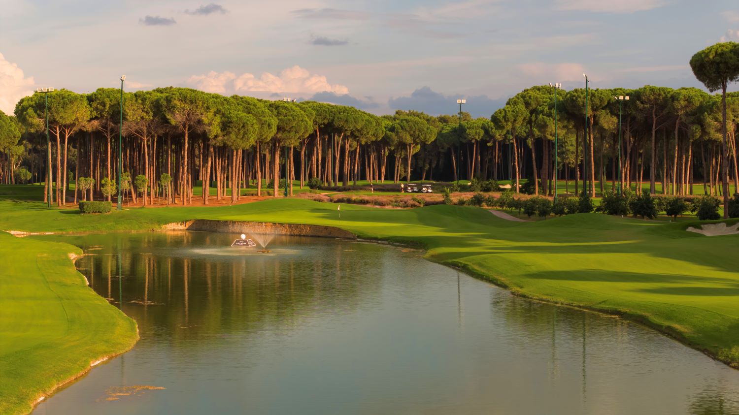 Trees and lake protecting the green at Carya Golf Club