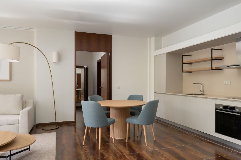 Dining table and chairs with kitchen units in the background at Marriott Residences Salgados Resort