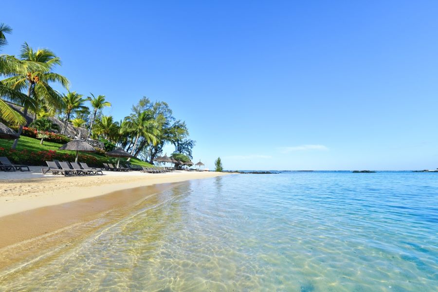 Sea lapping up to white sand on beach at Canonnier Beachcomber Golf Resort & Spa