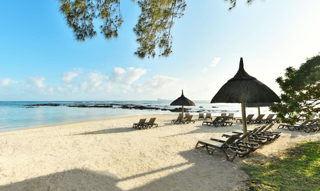 Parasols over sun lounger on beach at Canonnier Beachcomber Golf Resort & Spa