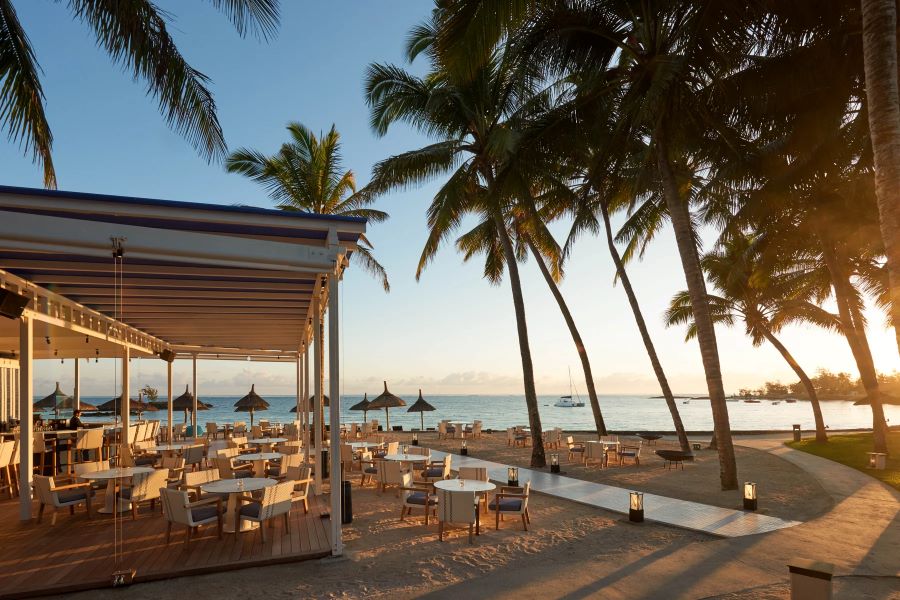 Restaurant with tables and chairs on the beach at Constance Belle Mare Plage Hotel Mauritius