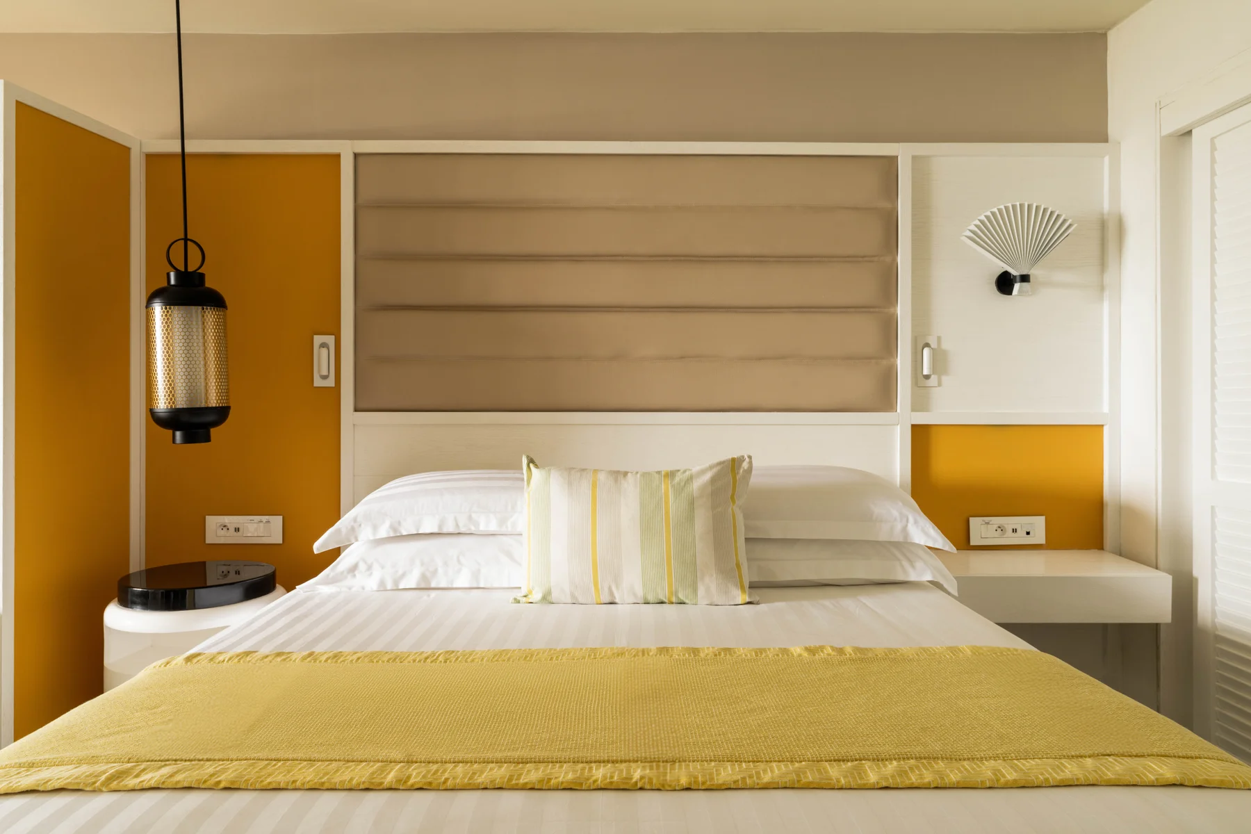 Bedroom with yellow throw on the bed at Constance Belle Mare Plage Hotel Mauritius