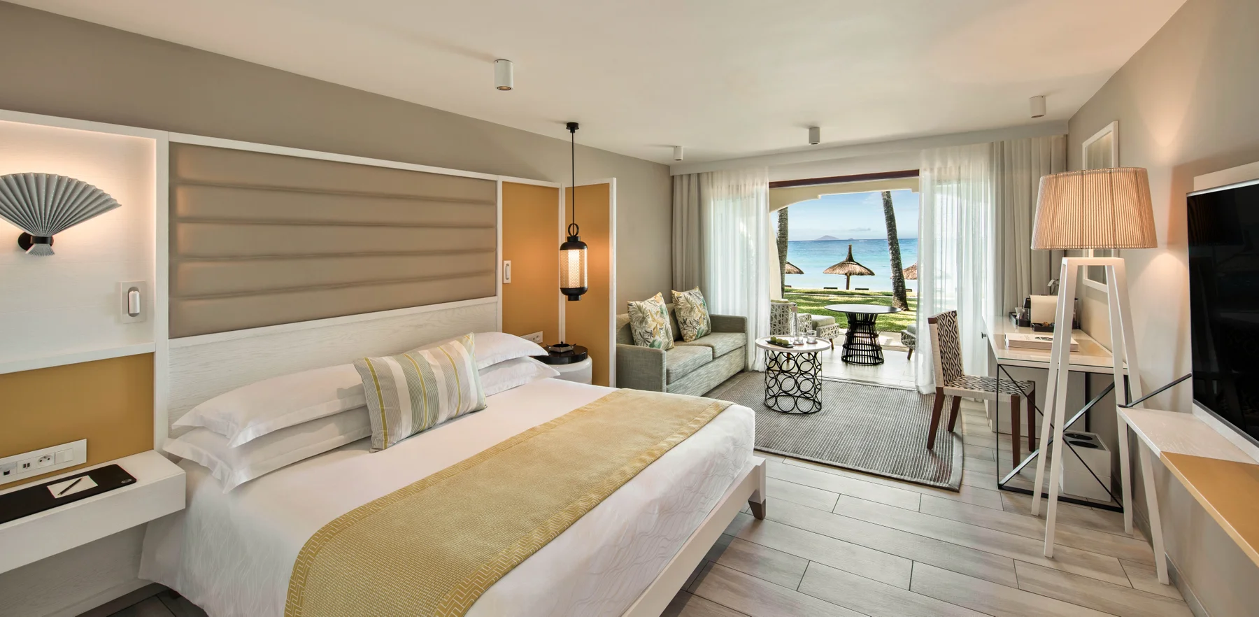 Bedroom with sofa and doors out to the beach at Constance Belle Mare Plage Hotel Mauritius