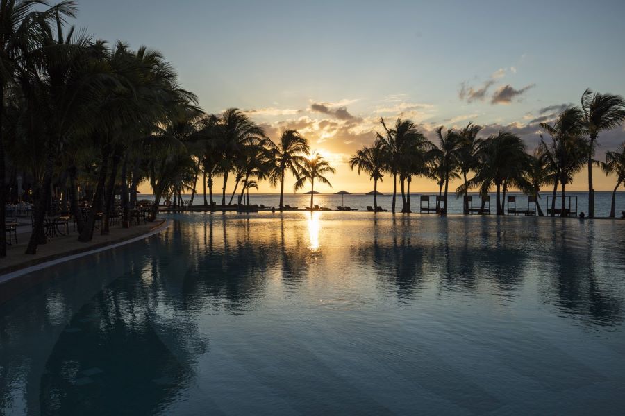 Sunset over the swimming pool at Dinarobin Beachcomber Golf Resort & Spa