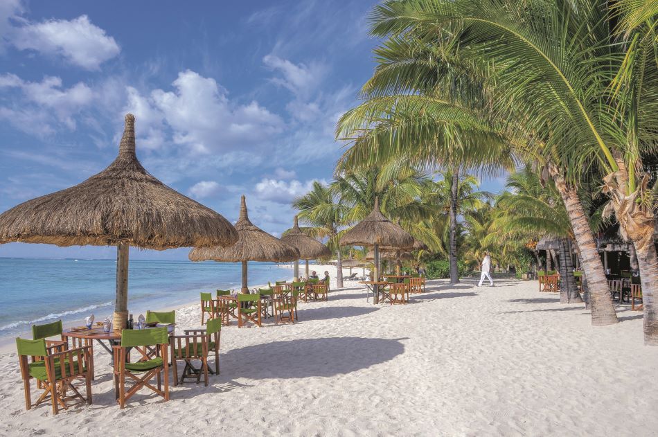 Tables and chairs on beach at Dinarobin Beachcomber Golf Resort & Spa