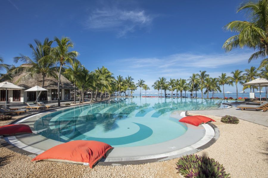 Pool area with red lounging areas at Dinarobin Beachcomber Golf Resort & Spa