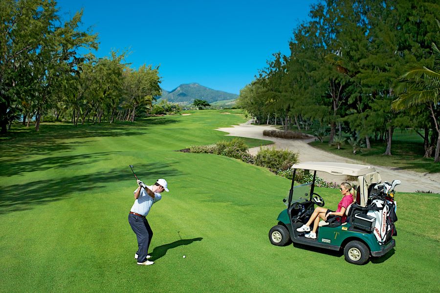 Golfer teeing off on the fairways at Ile aux Cerfs Golf Club in Mauritius