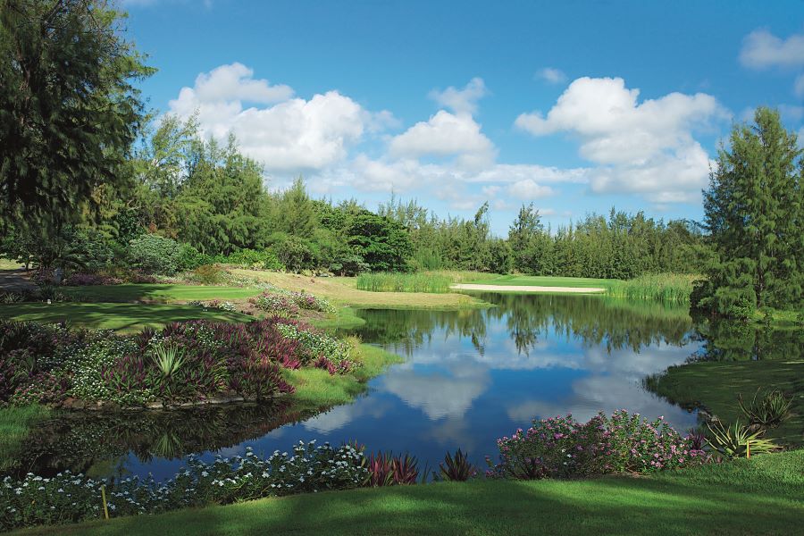 Lake with blue water and green trees surrounding the course at Ile aux Cerfs Golf Club