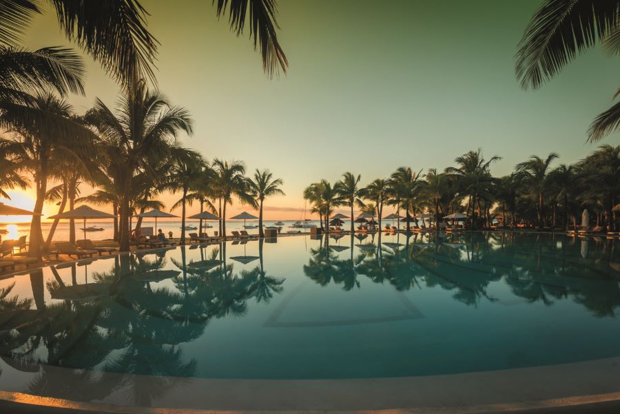 Swimming pool at night with palm trees surrounding at Paradis Beachcomber Golf Resort & Spa