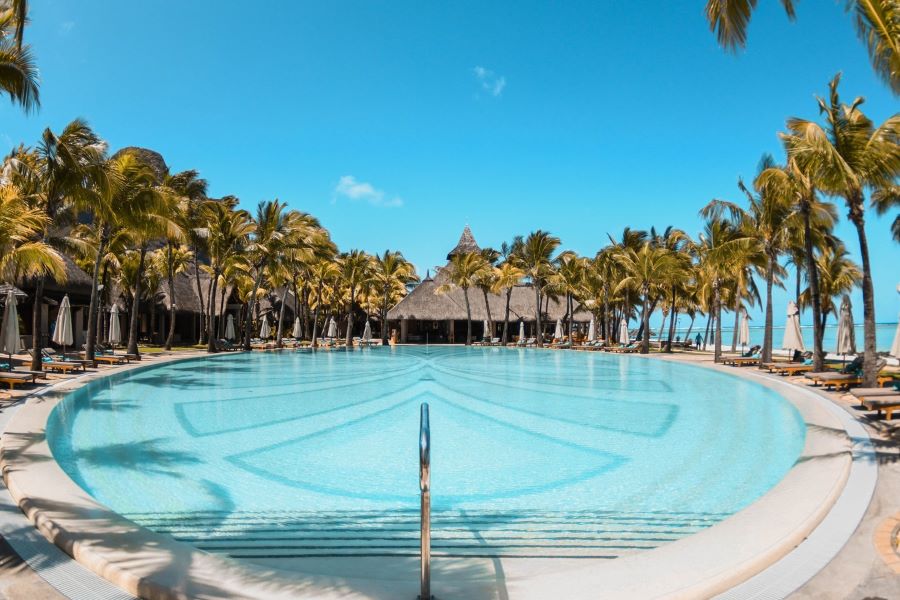 Swimming pool at Paradis Beachcomber Golf Resort & Spa surrounded by palm trees