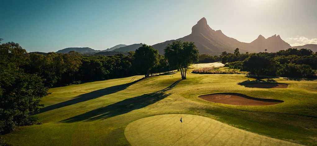 Mountain in the distance and sun shining over Tamarina Golf Club in Mauritius