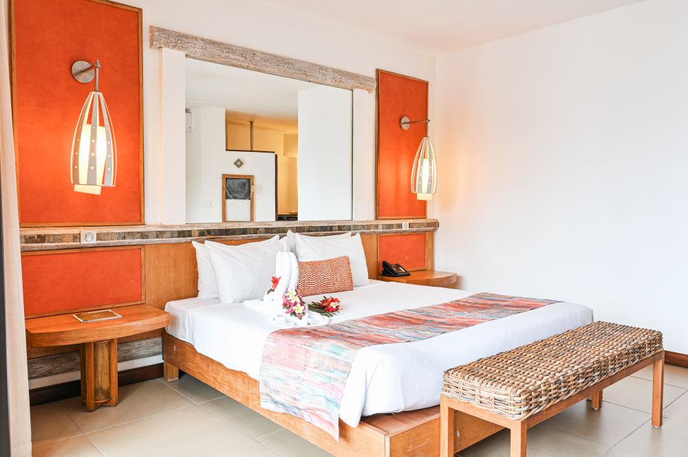 Bedroom with orange walls at Tamarina Golf & Spa Boutique Hotel