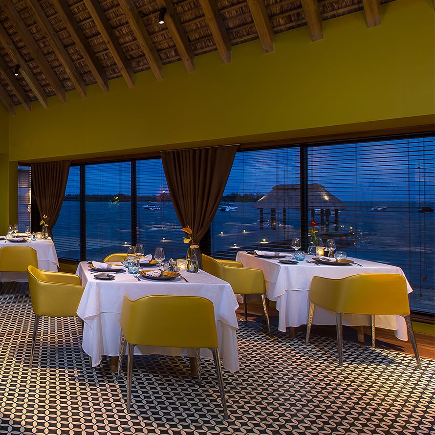 Dining restaurant with yellow chairs and view of the sea at Anahita Golf And Spa Resort