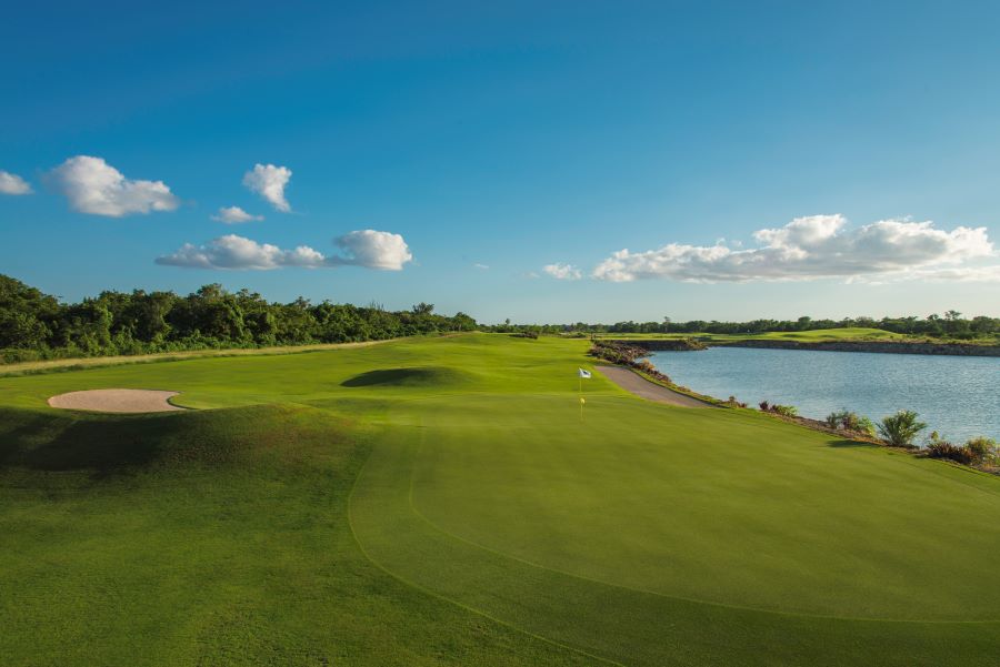 Lush green fairway with blue water to the right of the fairway at Dye Fore Golf Course