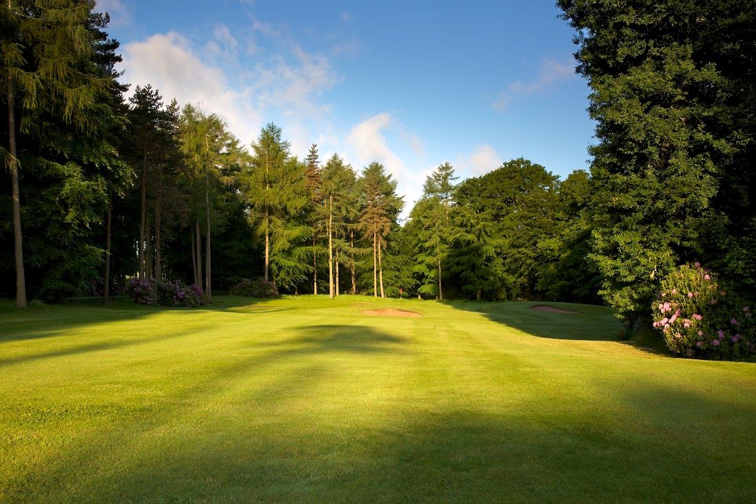 Lush green fairway protected by trees at Rudding Park