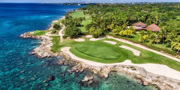 Putting green facing the turquoise water of the sea at Teeth of the Dog Golf Course in Dominican Republic