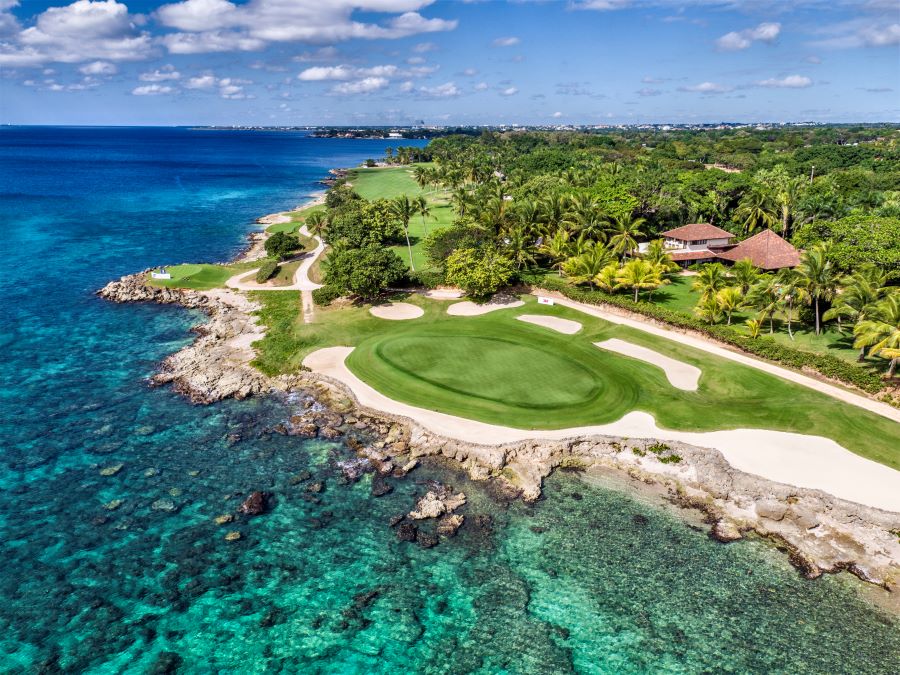 Putting green facing the turquoise water of the sea at Teeth of the Dog Golf Course in Dominican Republic