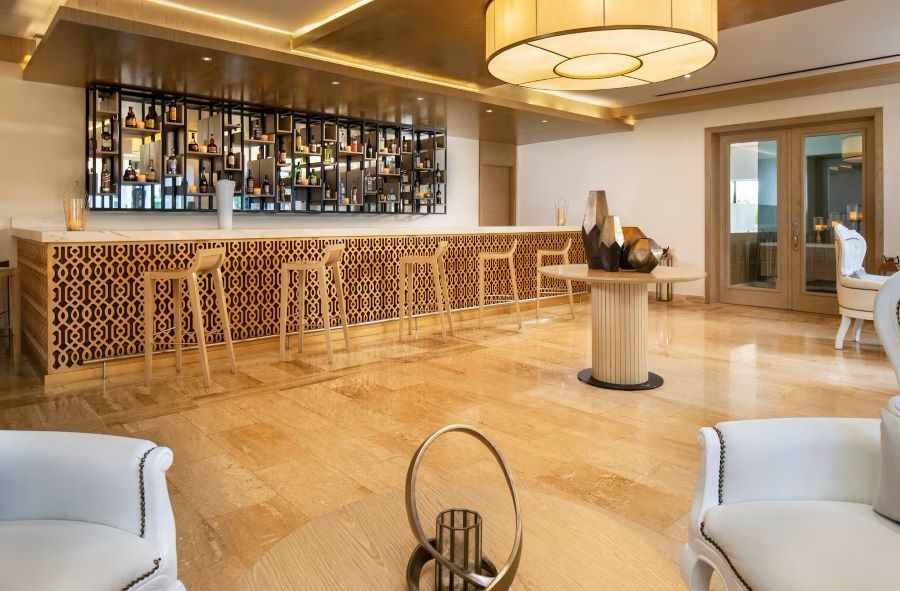 Stools in bar with drinks behind on the shelves at Melia Caribe Beach Resort