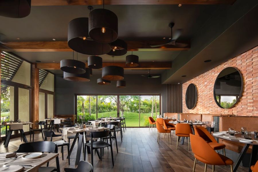 Orange chairs and tables set for service in restaurant at The Westin Puntacana Resort & Club