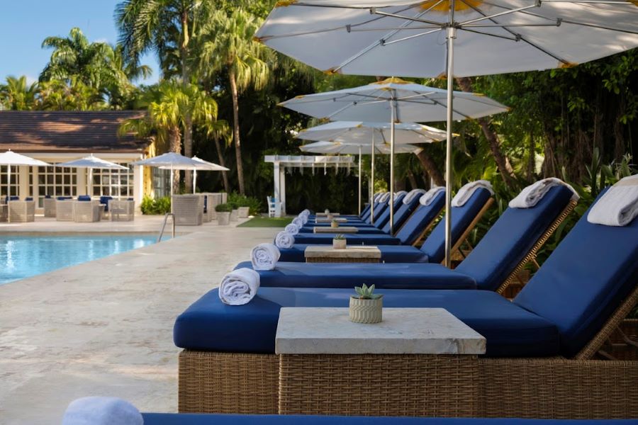 Blue sun loungers by the swimming pool with parasols at Tortuga Bay Hotel at Puntacana Resort & Club