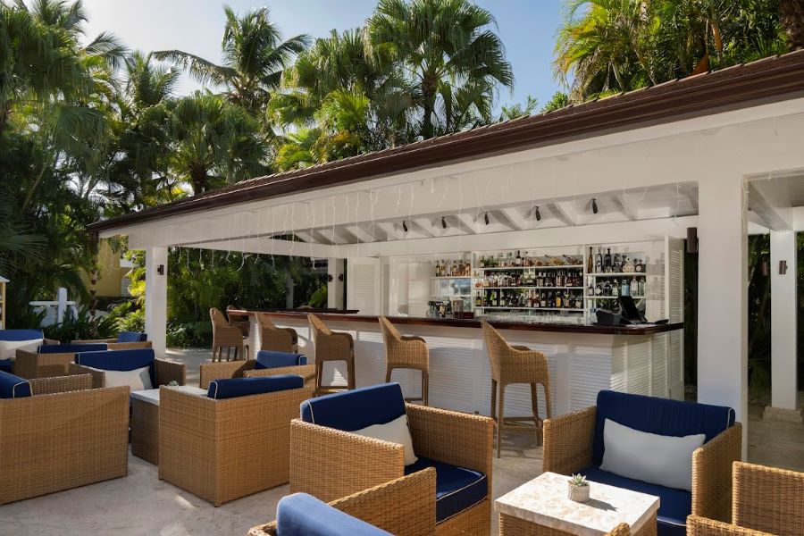 Pool bar with chairs and tables outside it at Tortuga Bay Hotel at Puntacana Resort & Club